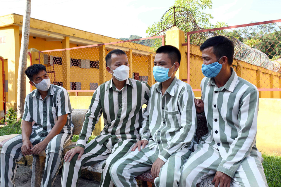 Phạm nhân T.M.C (thứ 2, bên trái qua) chia sẻ niềm vui với các phạm nhân trước ngày được đặc xá. (Ảnh: Phạm Kiên/TTXVN)