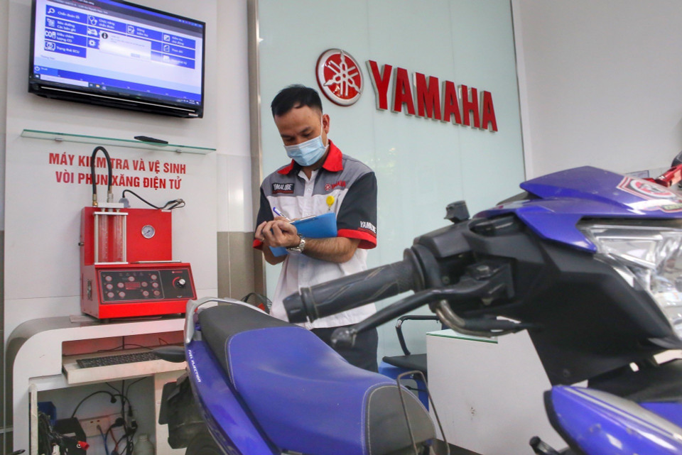 Nhân viên hãng ghi thông số sơ bộ của xe. (Ảnh: Tuấn Đức/TTXVN)