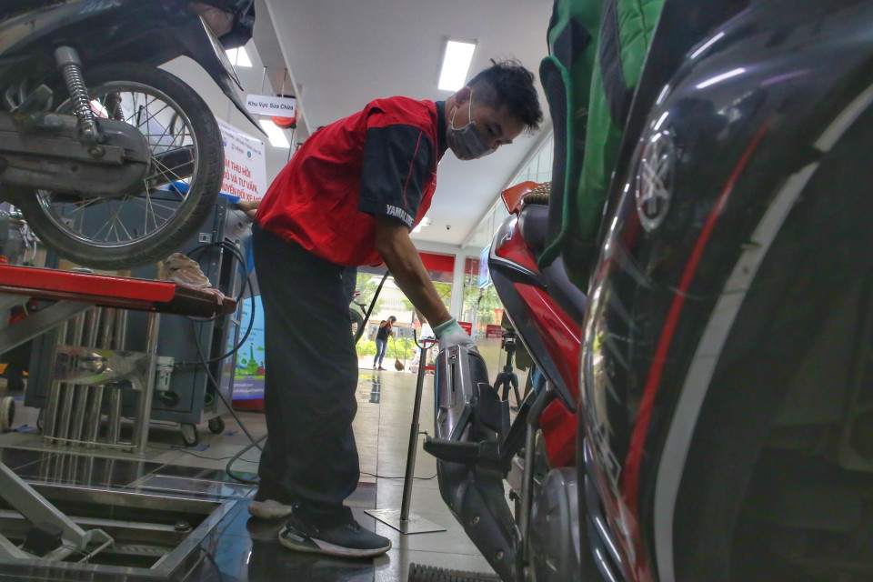 Các nhân viên kiểm tra khí thải xe máy. (Ảnh: Tuấn Đức/TTXVN)