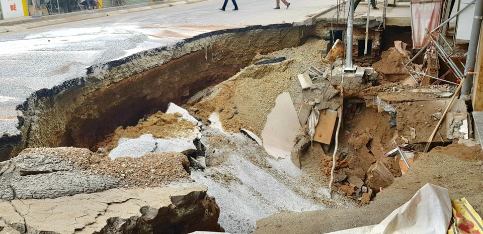 Sự cố sụt lún đất tạo thành hố sâu có chiều dài khoảng 15m và chiều rộng từ phía nhà dân ra mặt đường khoảng 7m. (Ảnh: Nguyễn Thắng/TTXVN)