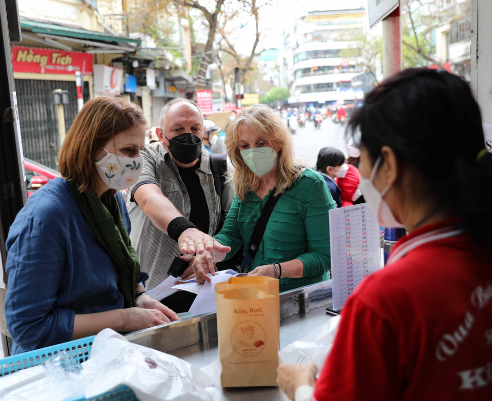 Du khách nước ngoài thưởng thức món ăn trong khu phố cổ Hà Nội. (Ảnh: Thanh Tùng/TTXVN)