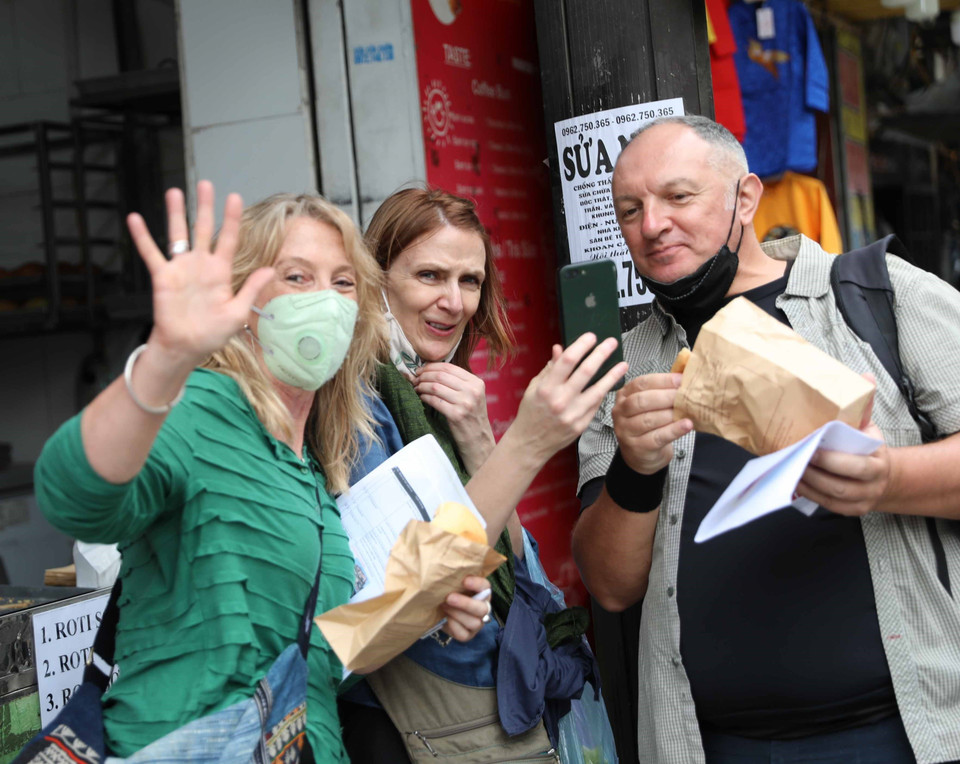 Du khách quốc tế hào hứng khi được hòa mình trong không gian phố cổ Hà Nội. (Ảnh: Thanh Tùng/TTXVN)