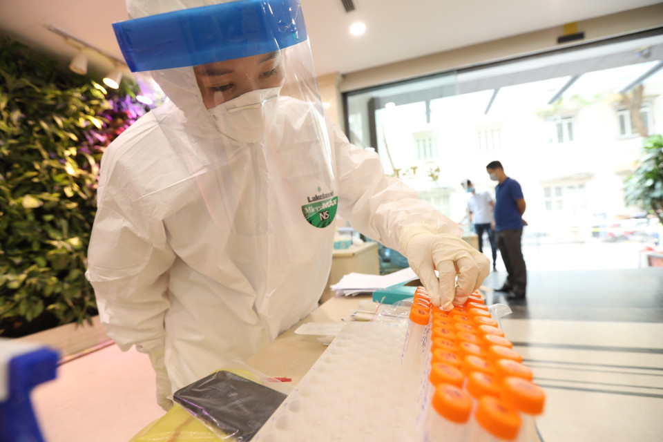 Người dân đến lấy mẫu tại tòa nhà T&amp;T Group. (Ảnh: Minh Quyết/TTXVN)