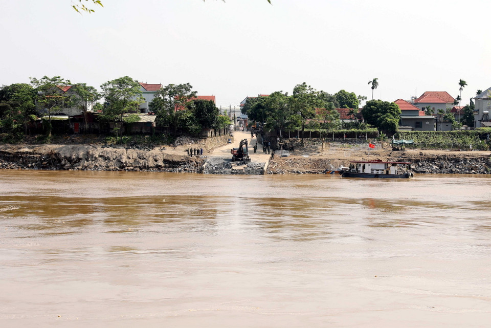 Lực lượng quân đội đang hoàn tất công đoạn cuối cùng ở 2 phía đầu đường dẫn trước khi lắp đặt cầu phao. (Ảnh: Tạ Toàn/TTXVN)