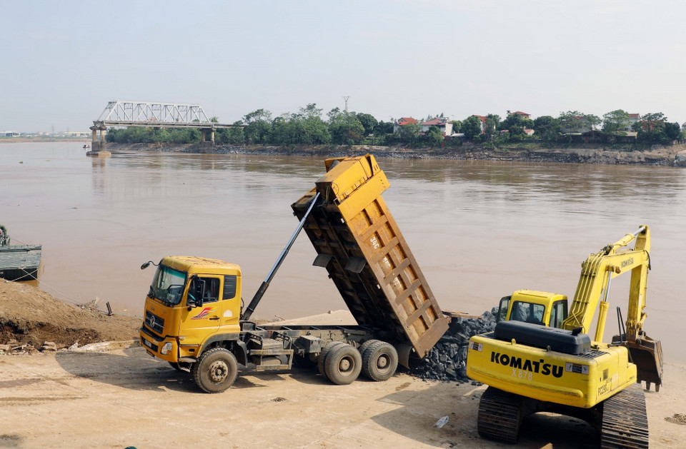 Lực lượng quân đội đang hoàn tất công đoạn cuối cùng ở 2 phía đầu đường dẫn trước khi lắp đặt cầu phao. (Ảnh: Tạ Toàn/TTXVN)