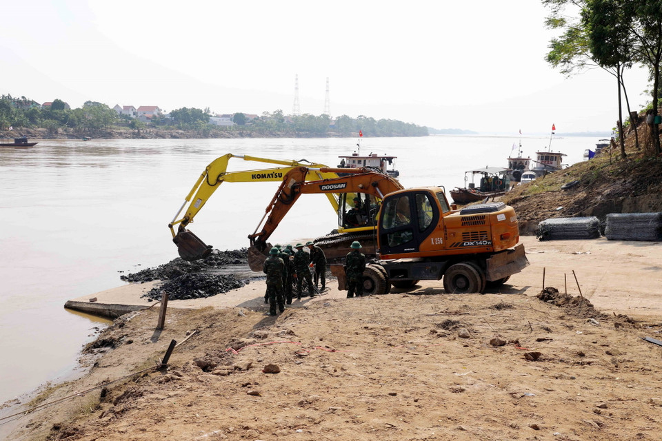 Quân đội tiếp tục khẩn trương gia cố bờ sông Hồng tại vị trí lắp đặt cầu phao. (Ảnh: Tạ Toàn/TTXVN)