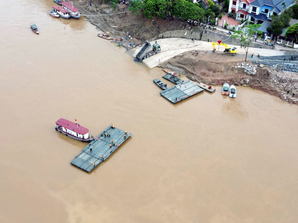 Việc hạ thủy nhịp cầu phao đầu tiên nhằm kiểm tra, đánh giá các tác động của dòng chảy, mực nước và các yếu tố kỹ thuật..., sau đó lực lượng quân đội sẽ sớm lắp cầu phao khi đảm bảo an toàn. (Ảnh: Tạ Toàn/TTXVN)