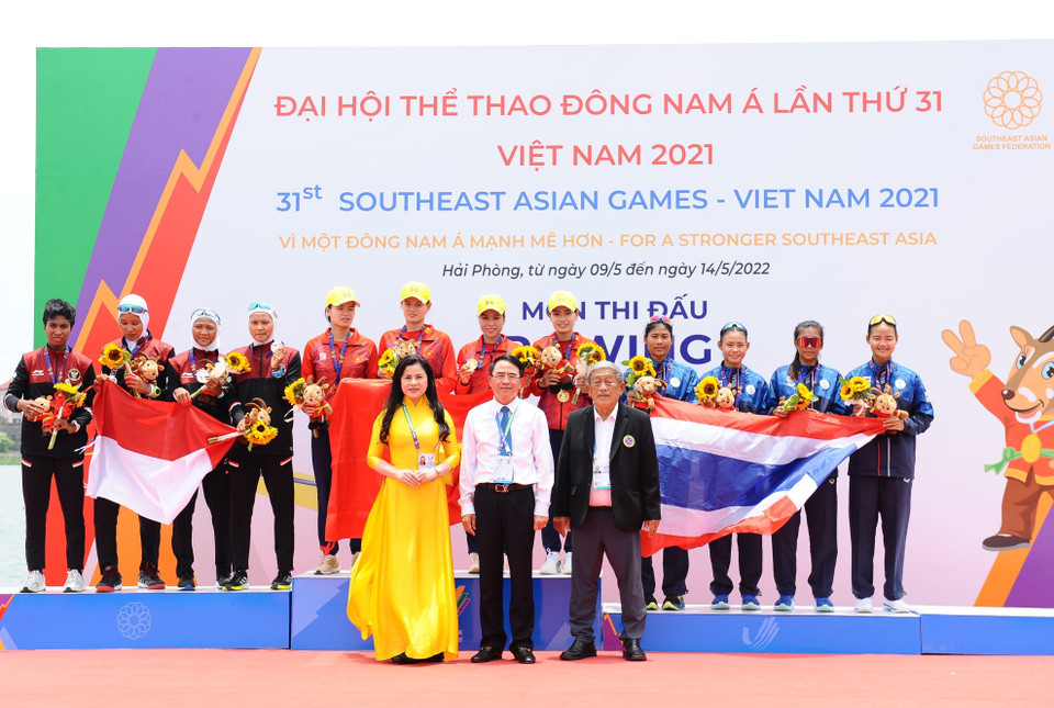 Ban tổ chức trao huy chương cho các đội nội dung thuyền 4 nữ hạng nặng chèo đơn (W4-), gồm Việt Nam (giữa - huy chương Vàng), Indonesia (trái - huy chương Bạc) và Thái Lan (phải - huy chương Đồng). (Ảnh: Minh Đức/TTXVN)