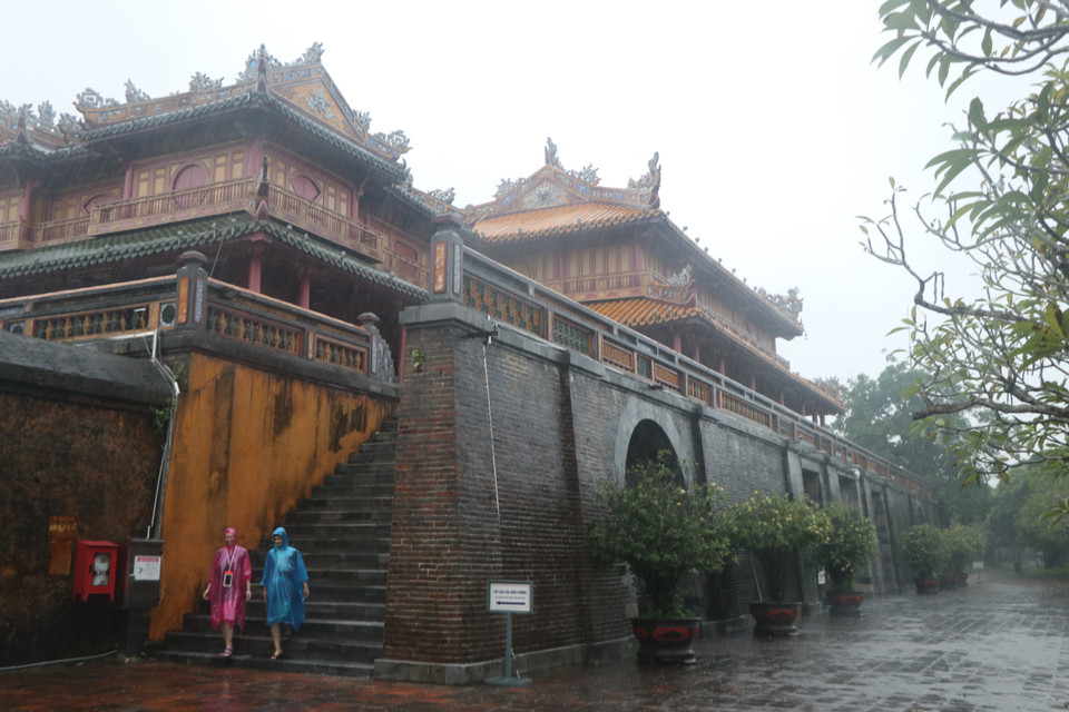 Du khách tham quan Đại Nội Huế trong mưa. (Ảnh: Đỗ Trưởng/TTXVN)