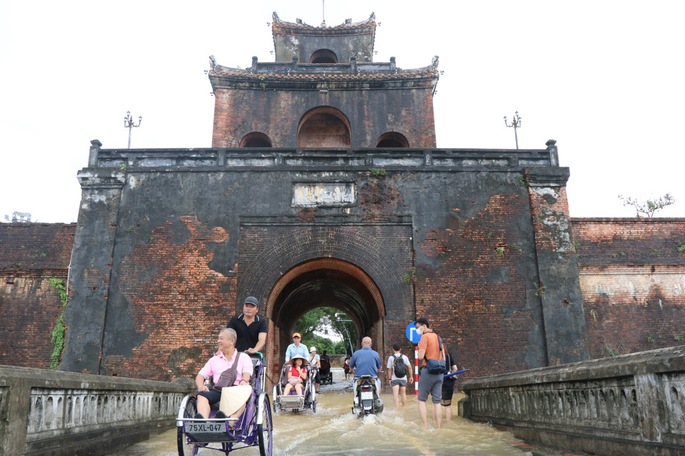 Du khách lựa chọn phương tiện xích lô để di chuyển trên những tuyến đường ở thành phố Huế vào mùa mưa. (Ảnh: Đỗ Trưởng/TTXVN)