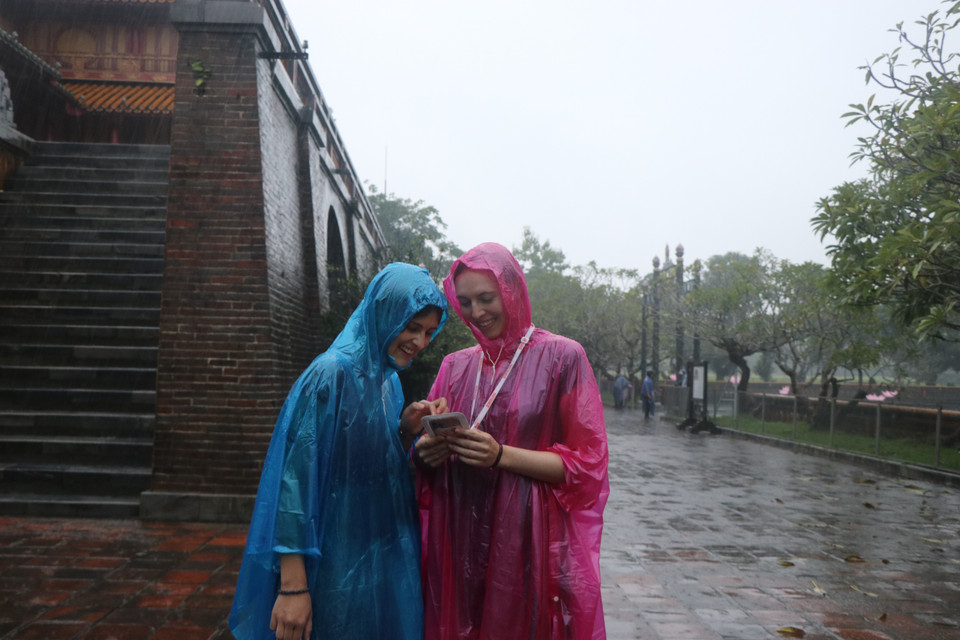 Du khách lưu lại những hình ảnh đẹp chụp tại Đại Nội Huế trong mưa. (Ảnh: Đỗ Trưởng/TTXVN)