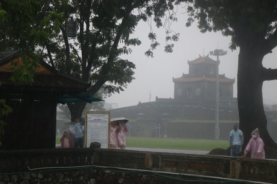 Du khách thích thú khám phá Huế trong mưa. (Ảnh: Đỗ Trưởng/TTXVN)