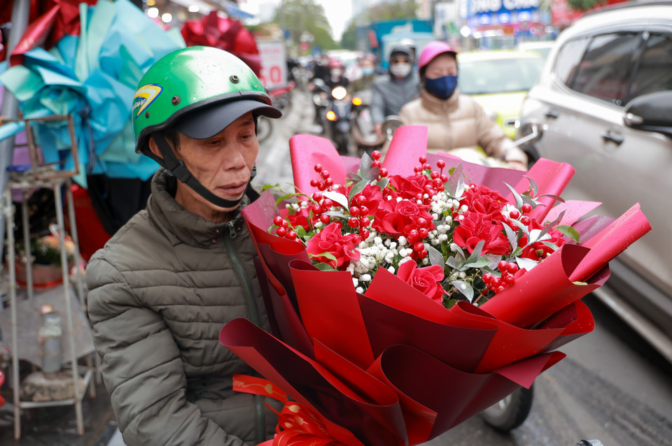Chú Hùng (quận Hai Bà Trưng) đi mua hoa sớm nhân ngày Lễ Tình nhân để tặng cho 'nửa kia' của mình. (Ảnh: Minh Hiếu/Vietnam+