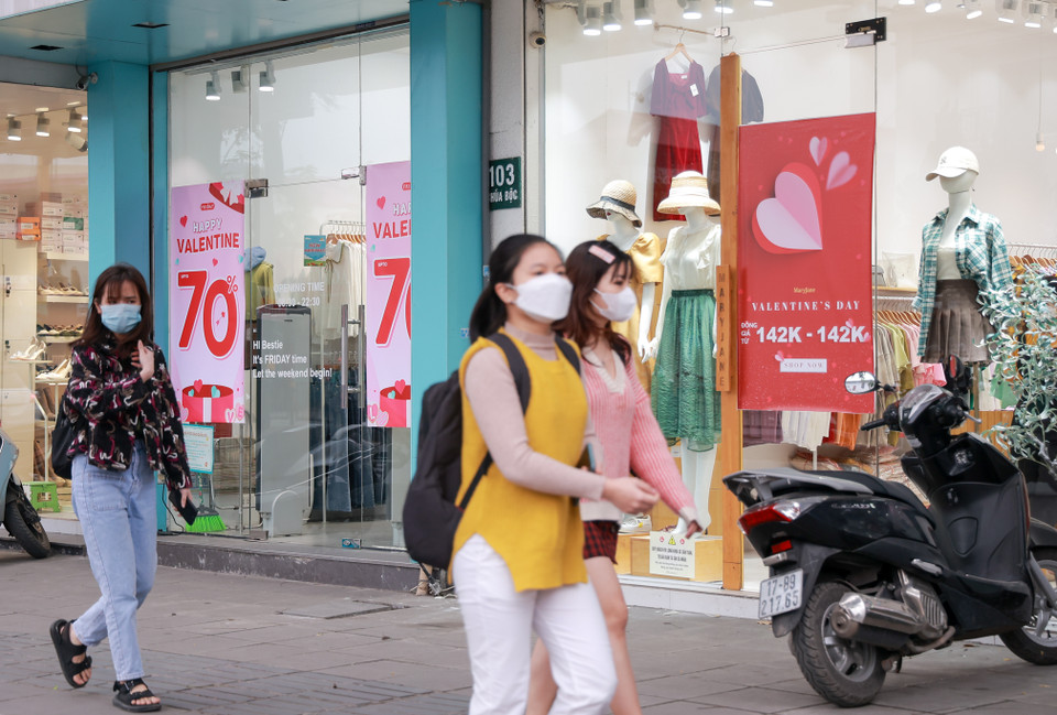 Các cửa hàng thời trang trên tuyến phố Chùa Bộc (quận Đống Đa) dày đặc áp phích khuyến mãi nhân dịp Valentine. (Ảnh: Minh Hiếu/Vietnam+)