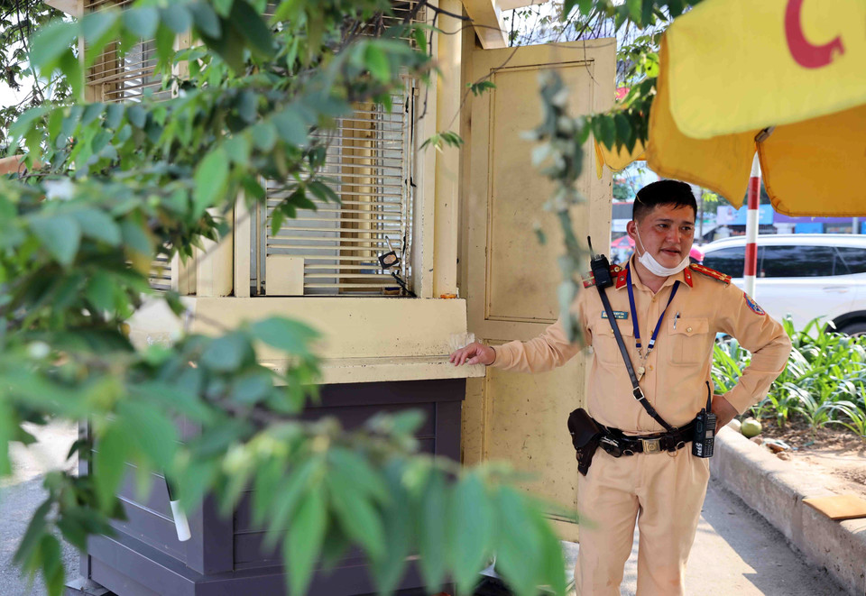 Phút nghỉ hiếm hoi của Đại uý Đào Duy Tân, đội Cảnh sát Giao thông số 3 sau khi liên tục điều tiết, phân luồng giao thông suốt nửa tiếng đồng hồ dưới trời nắng gay gắt 40 độ C. (Ảnh: Phạm Kiên/TTXVN)