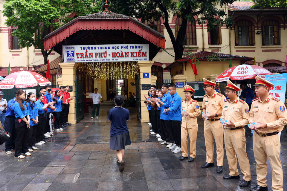 Lực lượng Cảnh sát Giao thông, Công an thành phố Hà Nội cùng thanh niên tình nguyện tiếp sức mùa thi tại điểm thi trường THPT Trần Phú-Hoàn Kiếm. (Ảnh: Phạm Kiên/TTXVN)