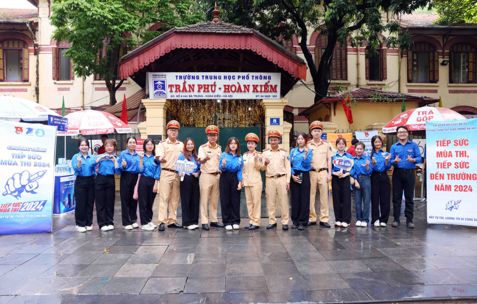 Lực lượng Cảnh sát Giao thông, Công an thành phố Hà Nội cùng thanh niên tình nguyện tiếp sức mùa thi tại điểm thi trường THPT Trần Phú-Hoàn Kiếm. (Ảnh: Phạm Kiên/TTXVN)