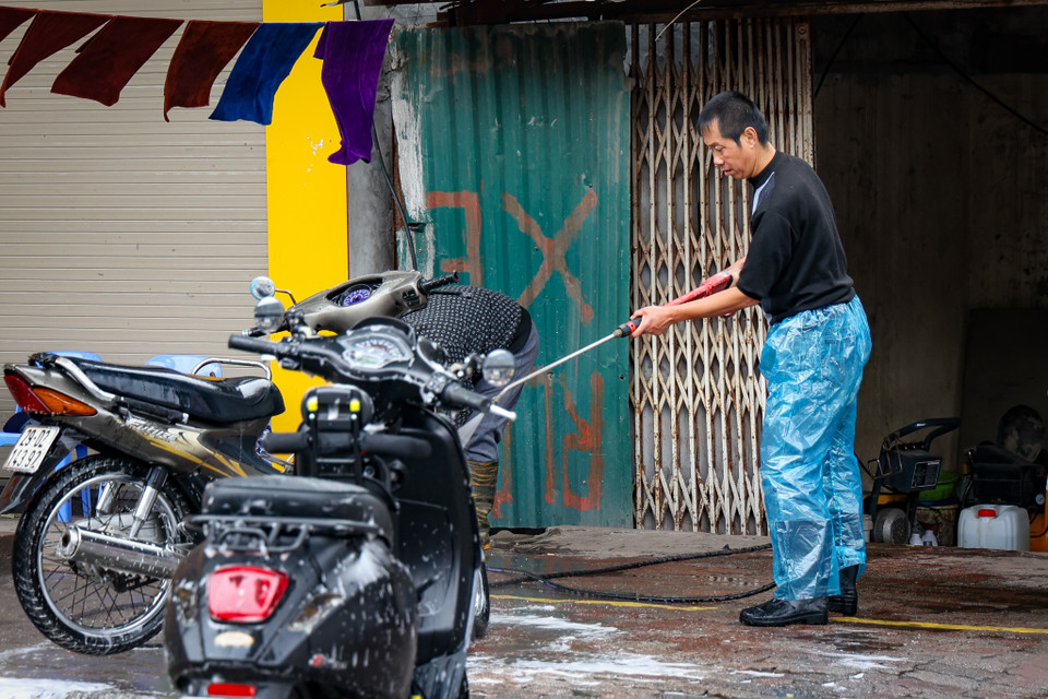 Một vài người vẫn tranh thủ kiếm thêm từ dịch vụ rửa xe cận Tết. Những ngày này, giá rửa xe cao gấp 2-3 lần ngày thường. (Ảnh: Minh Hiếu/Vietnam+)