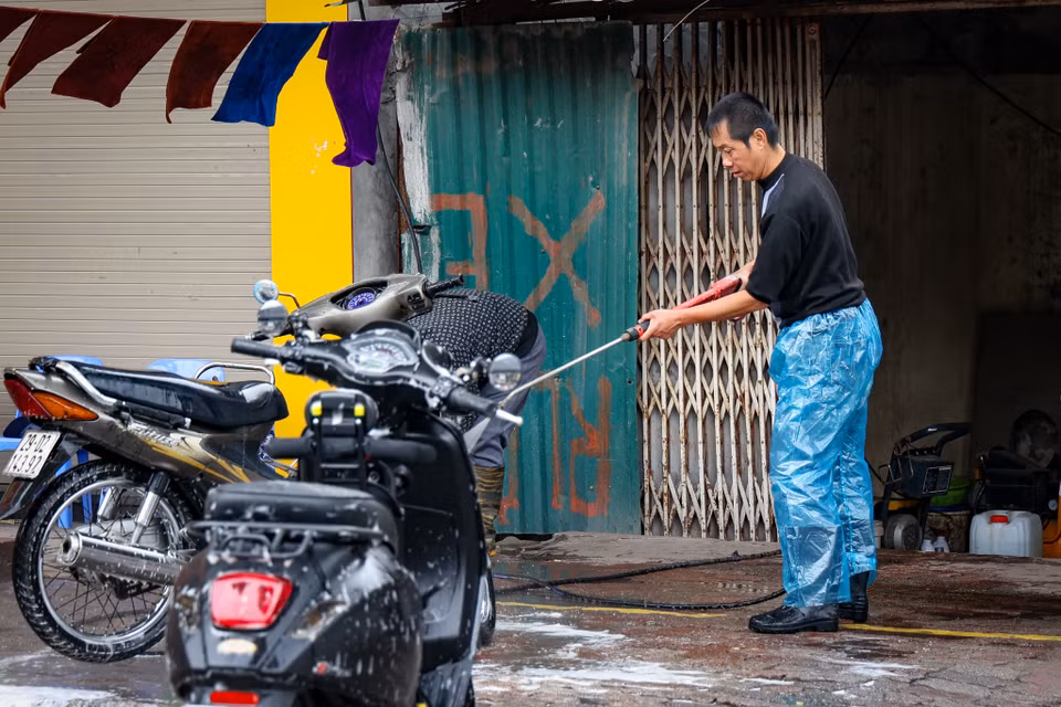 Một vài người vẫn tranh thủ kiếm thêm từ dịch vụ rửa xe cận Tết. Những ngày này, giá rửa xe cao gấp 2-3 lần ngày thường. (Ảnh: Minh Hiếu/Vietnam+)