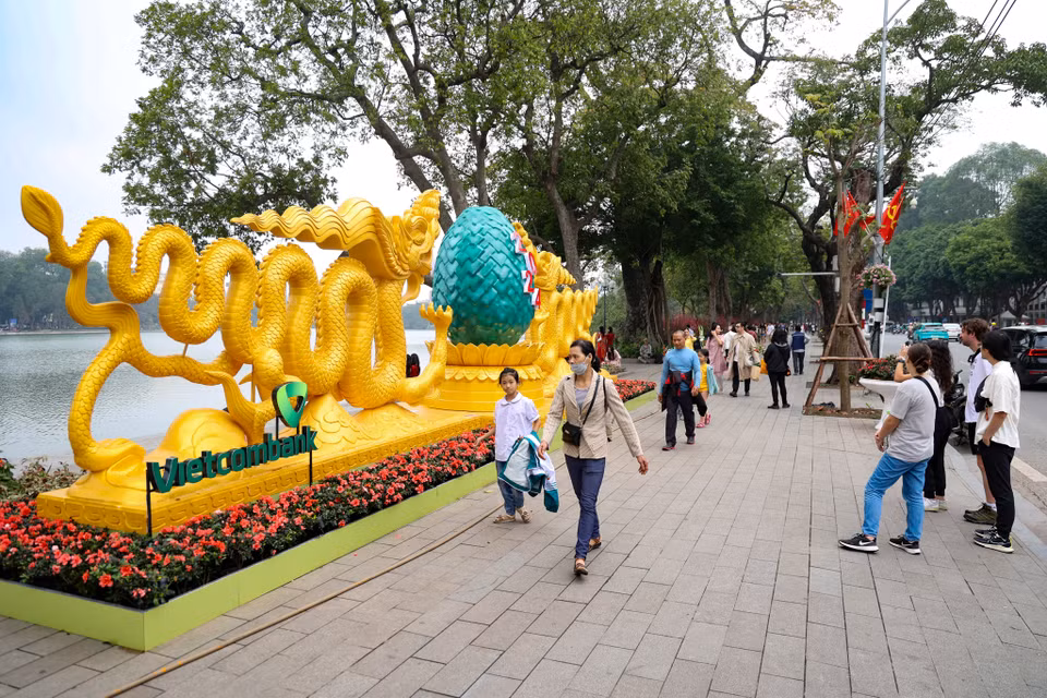 Nhiều người tranh thủ thời gian chọn cách đi dạo quanh Hồ Hoàn Kiếm để hòa nhịp vào không khí rộn ràng dịp cận Tết của Thủ đô. (Ảnh: Minh Hiếu/Vietnam+)