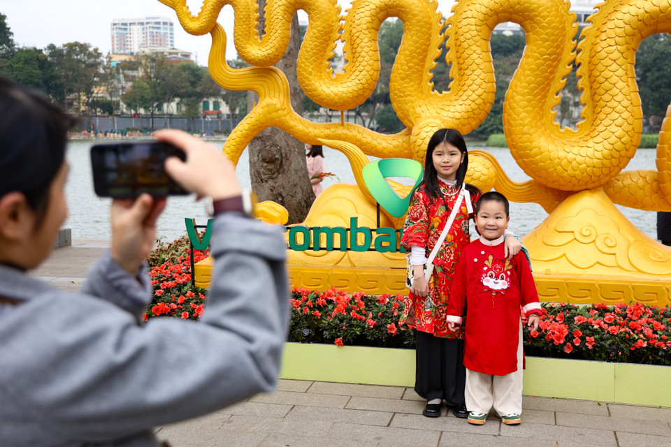 Người dân tranh thủ chụp ảnh kỷ niệm với trang phục đặc trưng của Tết. (Ảnh: Minh Hiếu/Vietnam+)