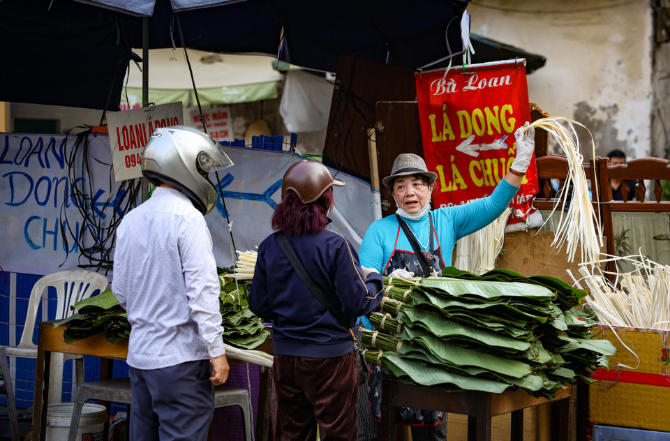 Bà Mai Loan, tiểu thương gần 50 năm bán lá dong tại chợ cho biết năm nay bà nhập hơn 10 vạn lá dong rừng để bán từ rằm tháng Chạp, lượng người mua nhiều nên có lúc hết cả lá để bán. Mỗi ngày bà bán được hơn 1 vạn lá dong và lạt buộc. (Ảnh: Minh Hiếu/Vietnam+)