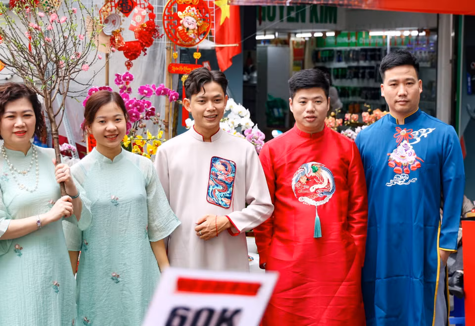 Không chỉ mua sắm hoa đào, cây quất, người dân khi đến đây còn khoác lên mình những chiếc áo dài hợp mốt để tận hưởng không khí cận Tết. (Ảnh: Minh Hiếu/Vietnam+)