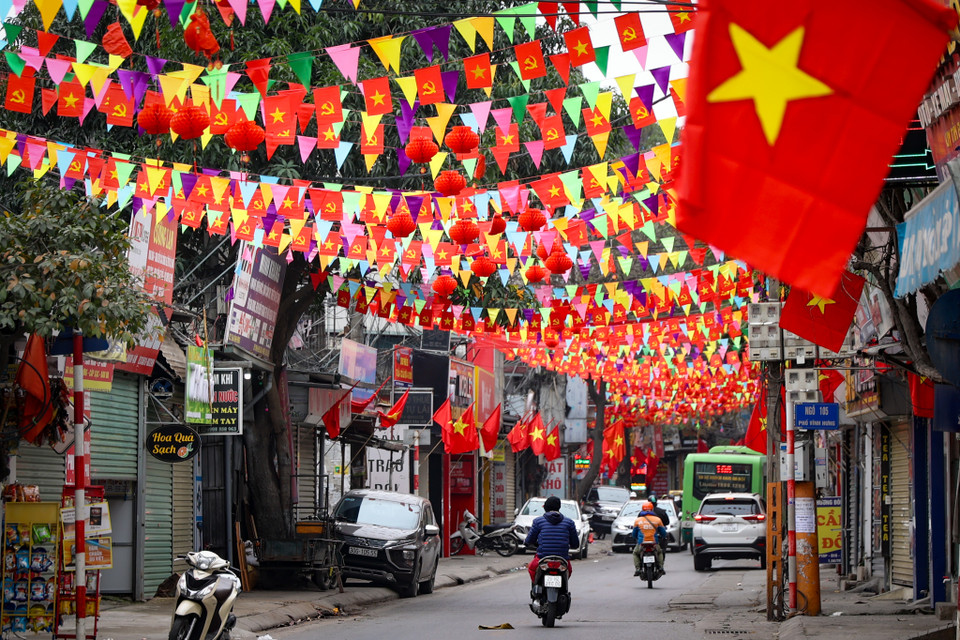 Cờ, hoa đỏ rợp cả con phố dịp Tết đến, Xuân về. (Ảnh: Minh Hiếu/Vietnam+)