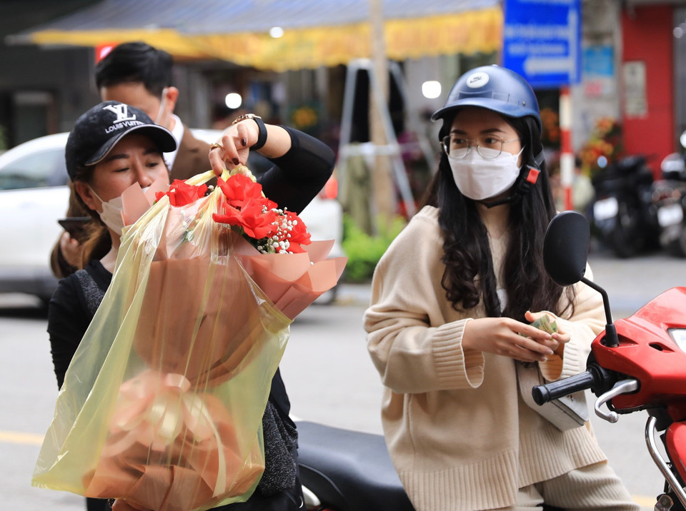 Khách mua hoa dịp 8/3 tại một hàng hoa trên phố Hai Bà Trưng. (Ảnh: Hoàng Hiếu/TTXVN)