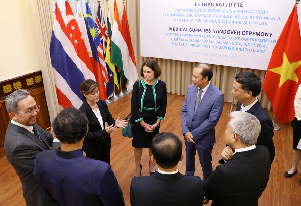 Thứ trưởng Bộ Ngoại giao Nguyễn Quốc Dũng trao đổi với đại diện các nước tại buổi lễ trao tặng hỗ trợ vật tư y tế phòng, chống COVID-19. (Ảnh: Văn Điệp/TTXVN)