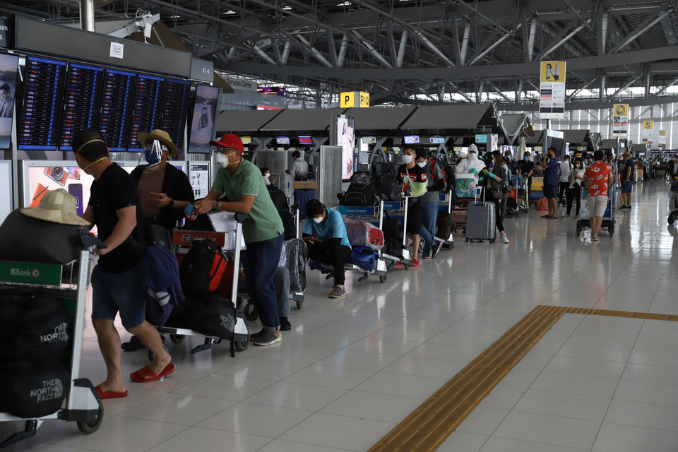 300 công dân Việt Nam xếp hàng chờ làm thủ tục chuyến bay. (Ảnh: Hữu Kiên/TTXVN)