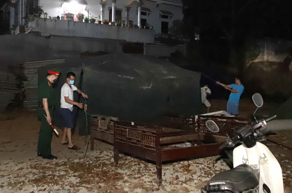 Lực lượng chức dựng lều bạt dã chiến tại Ngã 3 thôn Báo Văn 1, xã Đồng Văn, huyện Yên Lạc. (Ảnh: Hoàng Hùng/TTXVN)