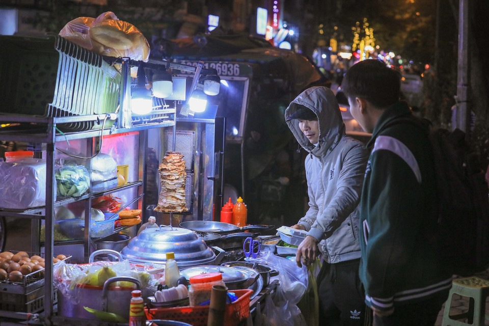 Các quán hàng bán đồ nóng thu hút khách hàng khi nhiệt độ giảm rõ rệt vào buổi đêm. (Ảnh: Hoàng Hiếu/TTXVN)
