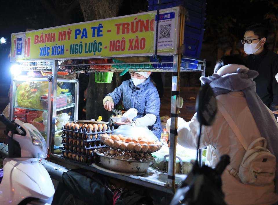 Các quán bán đồ ăn nóng thu hút nhiều khách hàng khi nhiệt độ tại Hà Nội giảm sâu đêm 22/1. (Ảnh: Hoàng Hiếu/TTXVN)