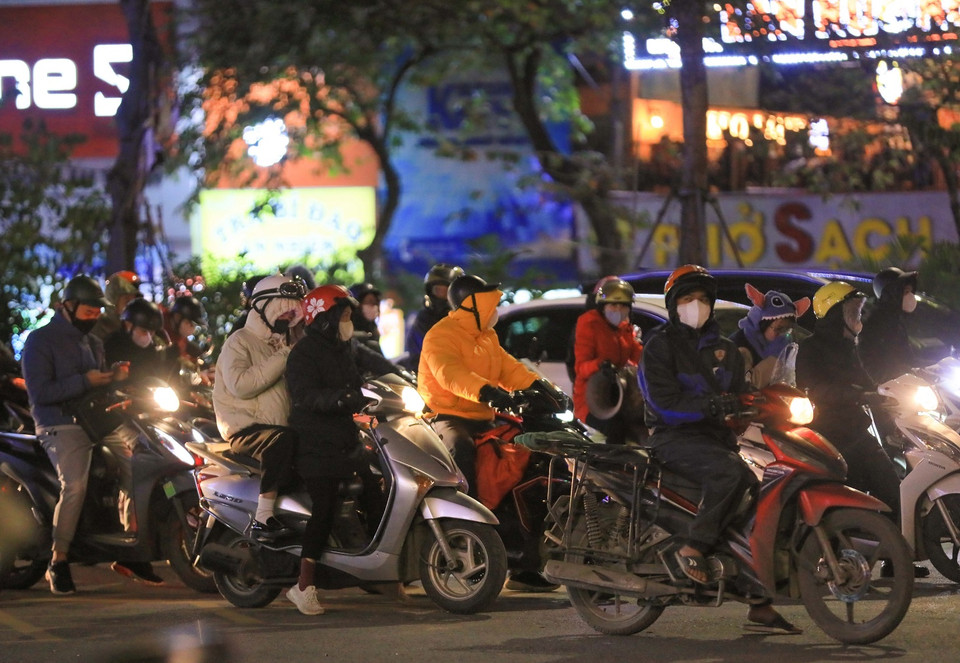 Thời tiết chuyển rét hại, người dân mặc thêm áo ấm, khẩu trang, găng tay khi phải di chuyển ngoài trời. (Ảnh: Hoàng Hiếu/TTXVN)