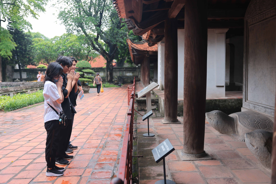 Thí sinh cầu may mắn tại khu vực nhà bia tiến sỹ Khu Di tích Quốc gia Đặc biệt Văn Miếu-Quốc Tử Giám. (Ảnh: Hoàng Hiếu/TTXVN)