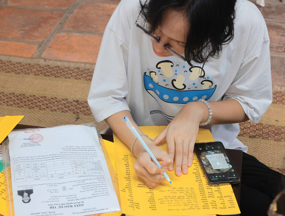 Nhiều thí sinh viết sớ, cầu mong thi tốt. (Ảnh: Hoàng Hiếu/TTXVN)