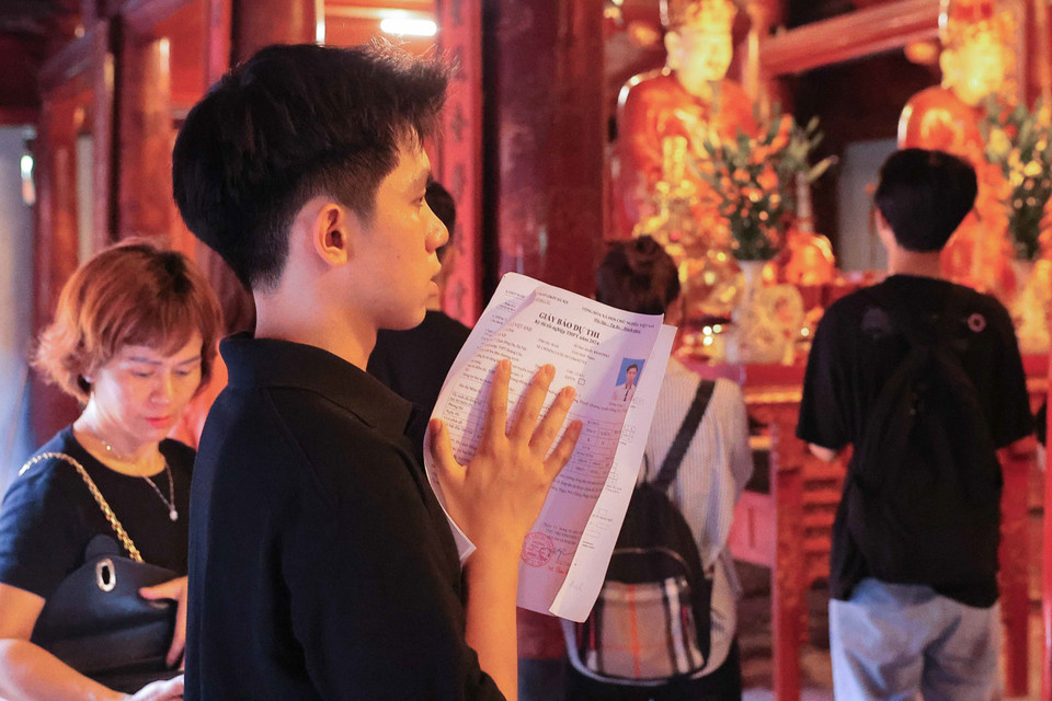 Một thí sinh mang cả giấy báo dự thi đến cầu thi tốt. (Ảnh: Hoàng Hiếu/TTXVN)