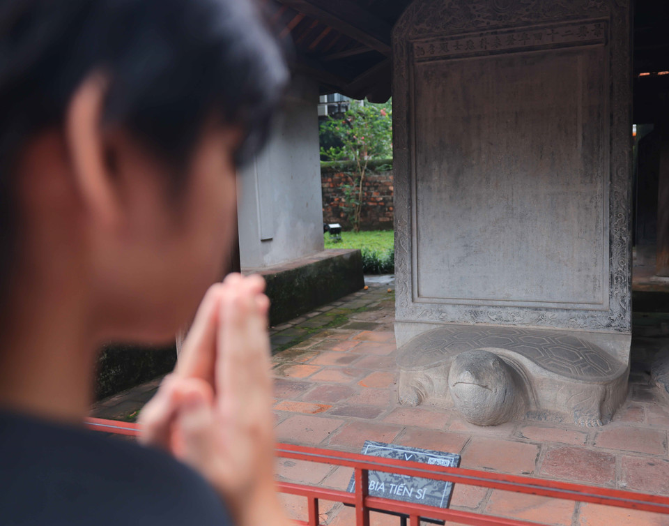 Thí sinh cầu may mắn tại khu vực nhà bia tiến sỹ Khu Di tích Quốc gia Đặc biệt Văn Miếu-Quốc Tử Giám. (Ảnh: Hoàng Hiếu/TTXVN)