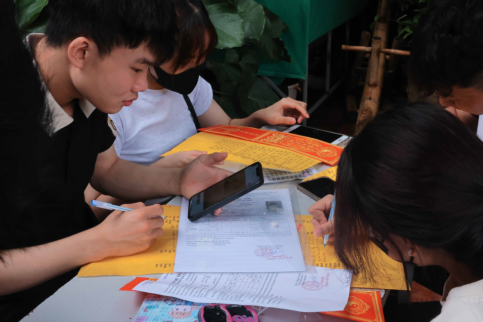 Nhiều thí sinh viết sớ, cầu mong thi tốt. (Ảnh: Hoàng Hiếu/TTXVN)