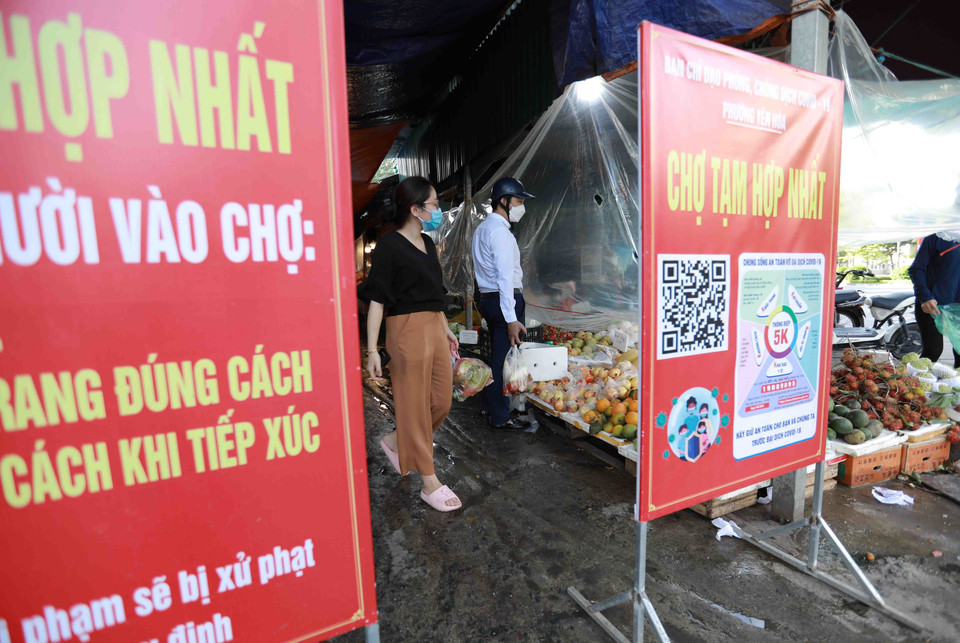 Ban quản lý chợ Hợp Nhất (phường Yên Hòa, quận Cầu Giấy) triển khai các bảng thông báo, hướng dẫn người dân thực hiện nghiêm các biện pháp phòng, chống dịch Covid-19 ngay tại cổng vào chợ. (Ảnh: Vũ Sinh/TTXVN)