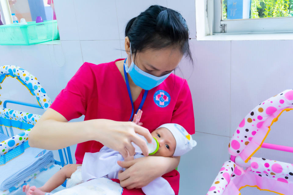 Bảo mẫu chăm sóc trẻ sơ sinh có mẹ mắc COVID-19 chờ người thân đón về. (Ảnh: TTXVN phát)