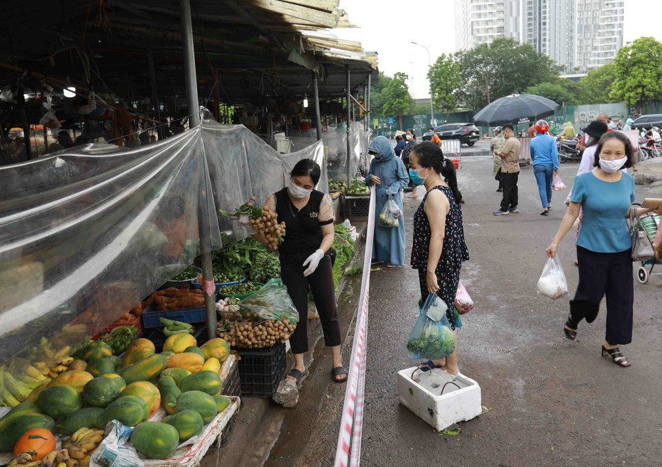 Chợ Nam Trung Yên (phường Trung Hòa, quận Cầu Giấy) triển khai căng giữ khoảng cách an toàn và có tấm kính chắn giữa người mua và bán hàng để đảm bảo phòng, chống dịch. (Ảnh: Vũ Sinh/TTXVN)