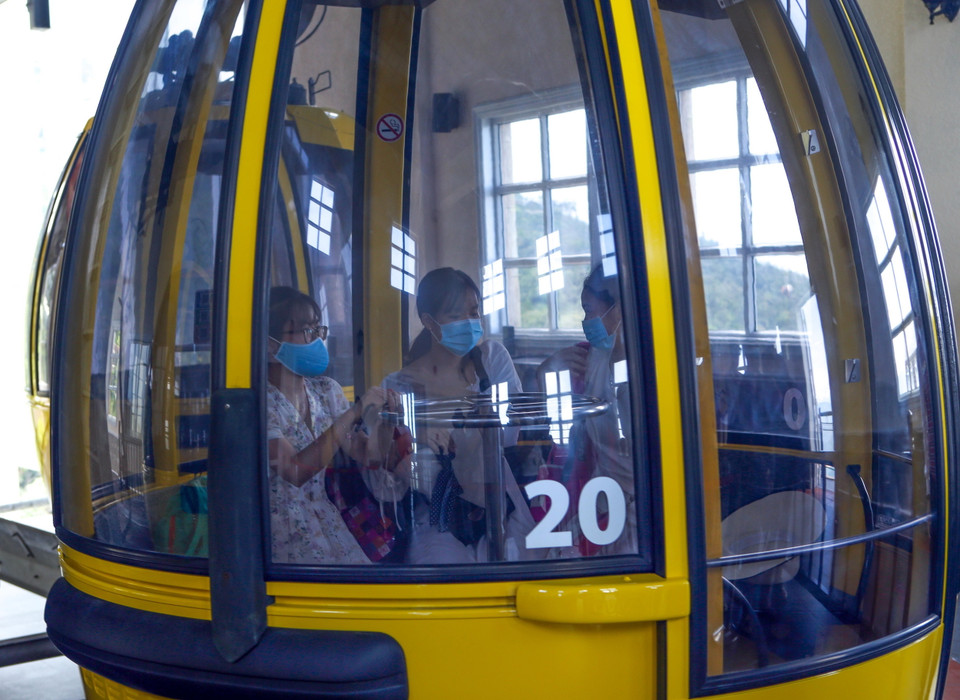 Mỗi cabin chỉ chở 1/2 số người theo quy định và phải đeo khẩu trang để phòng chống dịch tại Khu du lịch Bà Nà Hills. (Ảnh: Trần Lê Lâm/TTXVN)