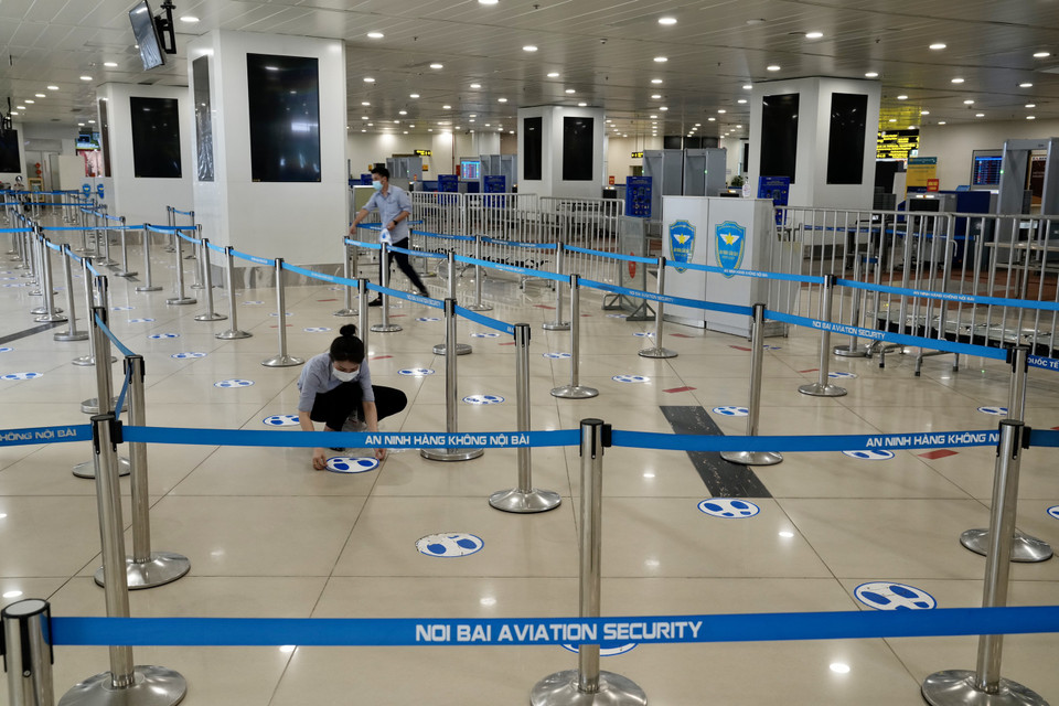Dán decal giữa khoảng cách tối thiểu 2m cho hành khách vào khu vực soi chiếu an ninh theo quy định của Bộ Y tế để đảm bảo phòng chống dịch. (Ảnh: CTV/Vietnam+)