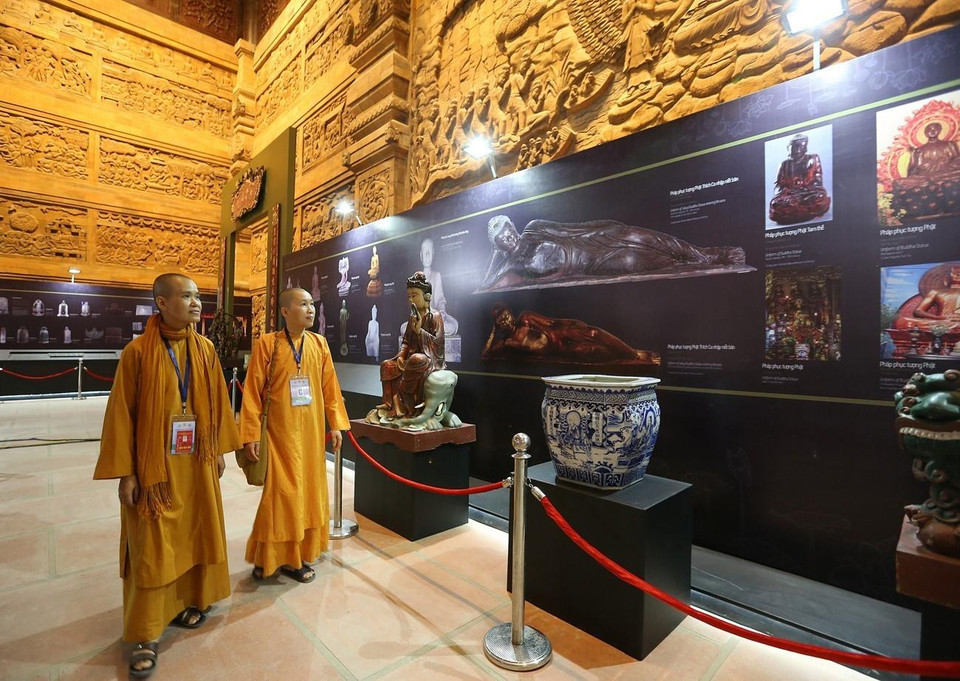 Các đại biểu tham quan Triển lãm tranh, ảnh và các tác phẩm văn hóa Phật giáo tại Điện Quan Âm. (Ảnh: Dương Giang/TTXVN)
