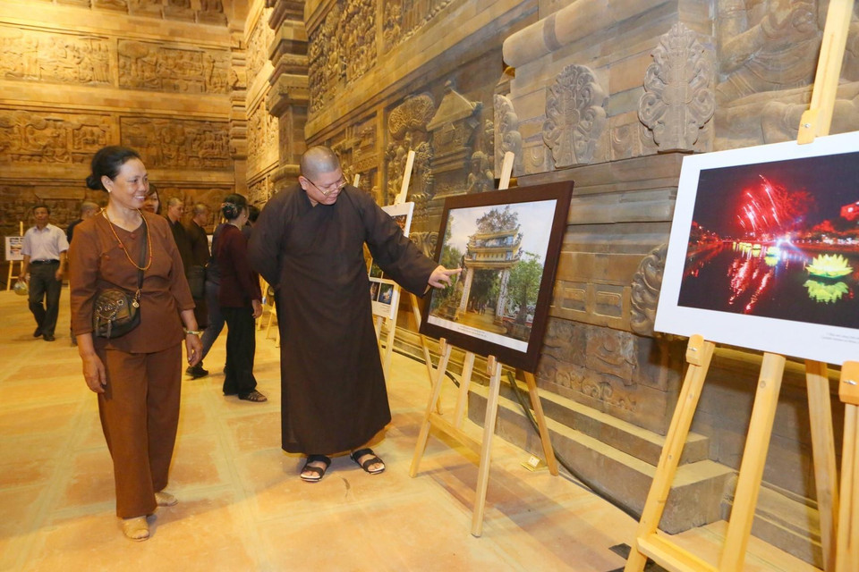 Các tăng ni Phật tử và du khách thập phương tham quan triển lãm ảnh Phật giáo. (Ảnh: Dương Giang/TTXVN)