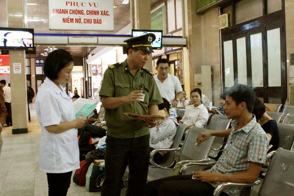 Ga Hà Nội - đơn vị điển hình của Thủ đô trong công tác phổ biến và thực hiện Luật Phòng chống tác hại thuốc lá cử cán bộ cấp phát tờ rơi, kiểm tra, nhắc nhở hành khách hút thuốc đúng nơi quy định. (Ảnh: Dương Ngọc/TTXVN)