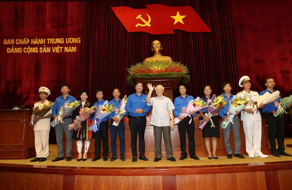 Tổng Bí thư, Chủ tịch nước Nguyễn Phú Trọng tặng hoa các đảng viên trẻ tiêu biểu. (Ảnh: Trí Dũng/TTXVN)