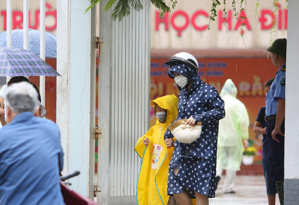 Các bậc phụ huynh đón con nhỏ luôn đeo khẩu trang tại Trường Tiểu học Hạ Đình, cách hiện trường vụ cháy nhà xưởng Công ty Rạng Đông chưa đến 1km. (Ảnh: Thành Đạt/TTXVN)